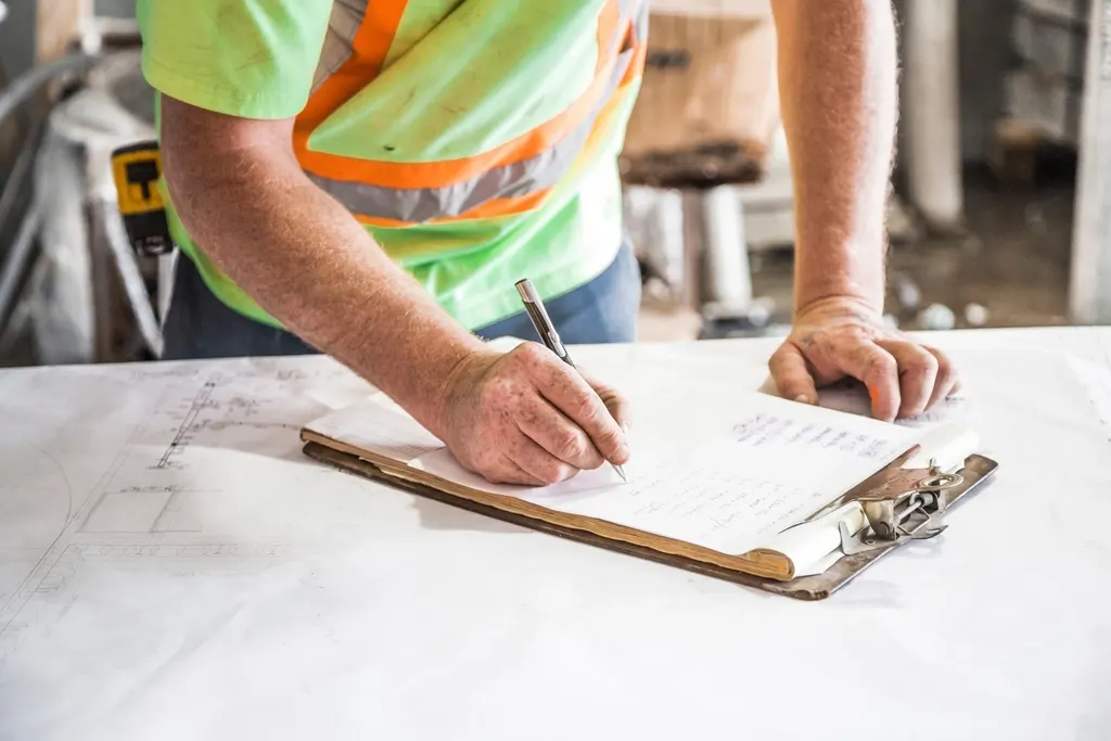 Person reviewing plans on a clipboard (stock image)